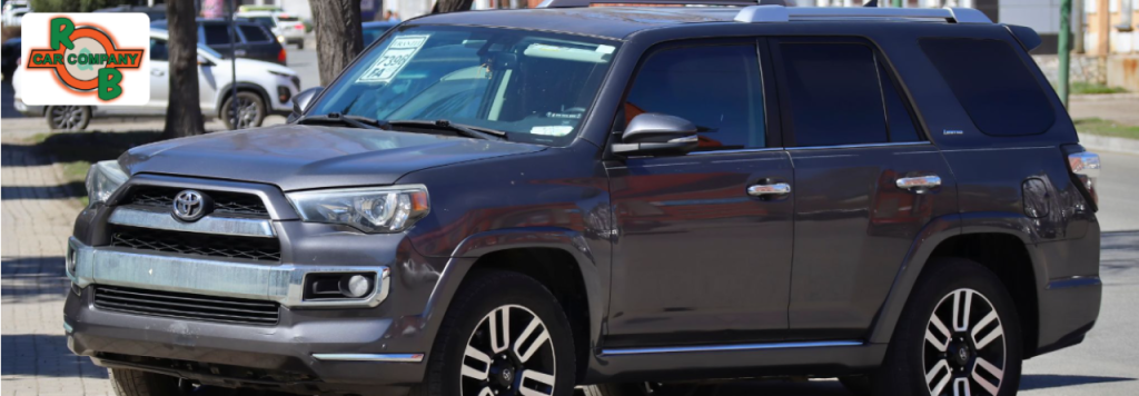 Wide-angle view of R&B Car Company Fort Wayne dealership lot with a variety of used cars under clear Indiana skies.
